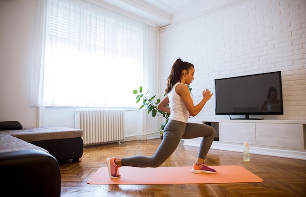 Mujer joven practicando ejercicios en casa