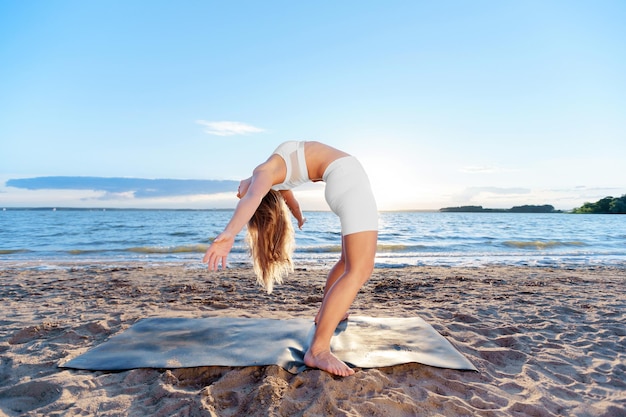 Mujer joven practicando ejercicios de yoga de pie backbend backbe