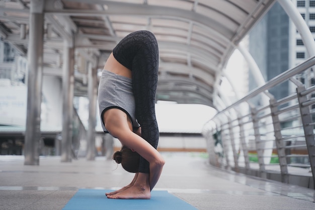 Mujer joven practicando pose de árbol en la vida urbana fitness actividad concepto salud