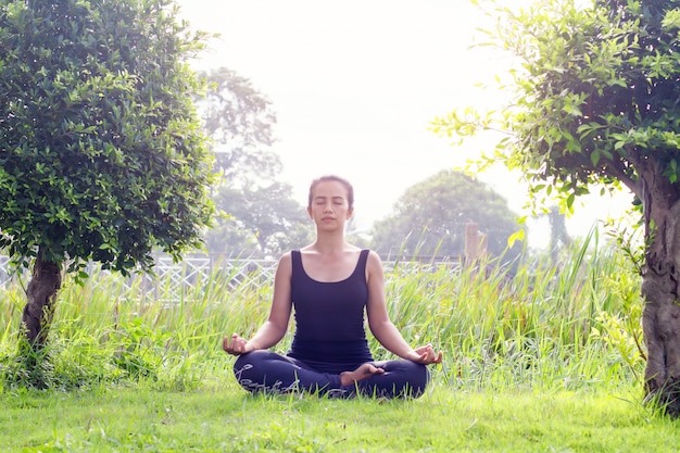 Foto mujer joven practicando yoga en el parque