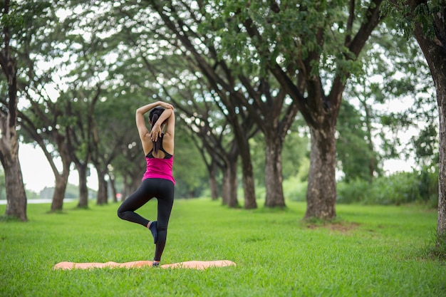 Mujer joven practicando yoga en el parque