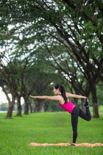 Mujer joven practicando yoga en el parque