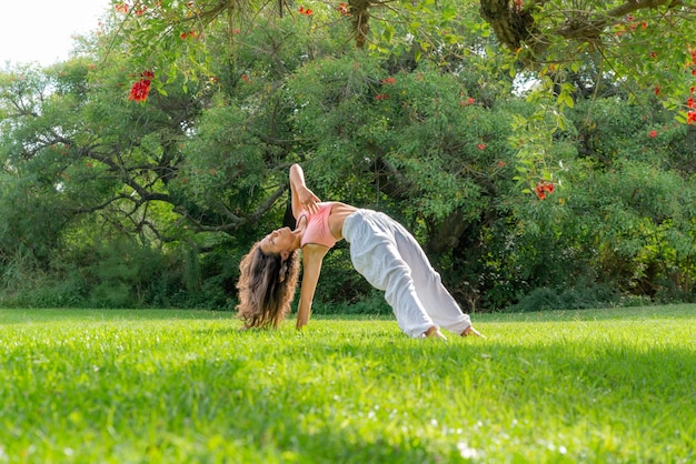 mujer joven, practicar, yoga, en, un, verde, parkwellness, concepto