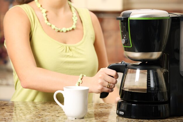 mujer joven preparando café por la mañana