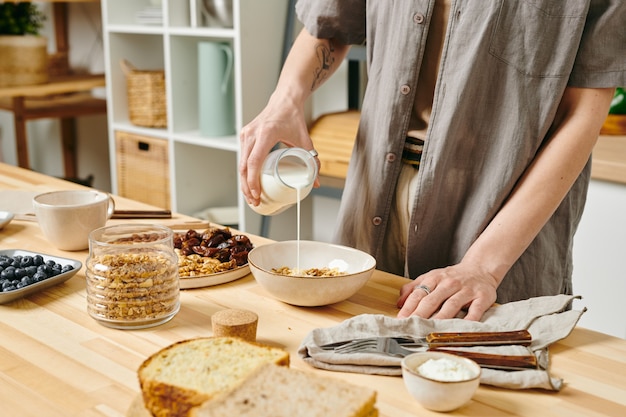 Mujer joven preparando comida en una mesa por la mañana