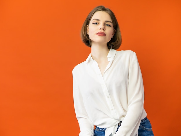 Mujer joven en la presentación en blanco blanca de la camiseta.