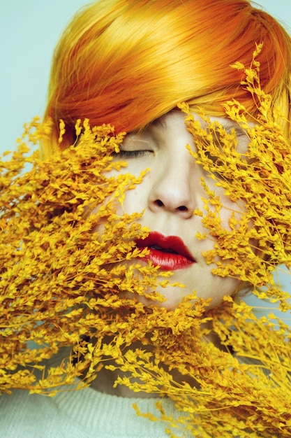 Mujer joven de primer plano con cabello rojo y plantas