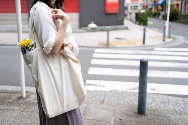 mujer joven, proceso de llevar, bolso de mano, vista lateral