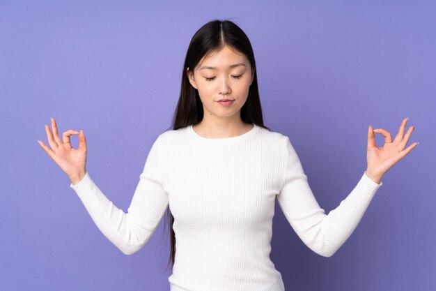 Mujer joven en púrpura en pose zen