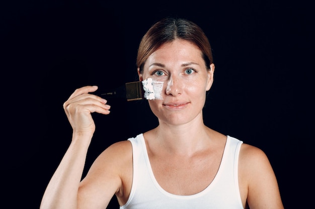 Mujer joven que aplica maquillaje pinta la cara con pincel y maquillaje Cómo no hacer el concepto de maquillaje