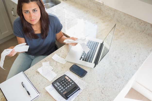 Mujer joven que calcula cuentas y que parece preocupado