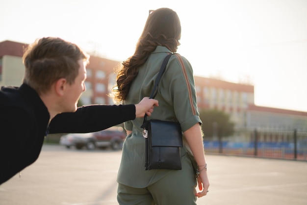 Una mujer joven que camina en la calle de la ciudad y un ladrón intenta robar su bolso, concepto criminal y de violencia