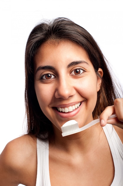 mujer joven que se cepilla los dientes