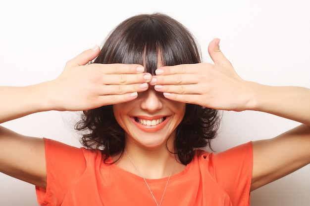 Foto mujer joven que cubre sus ojos con las manos.