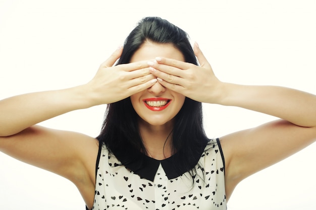 Mujer joven que cubre sus ojos con las manos.