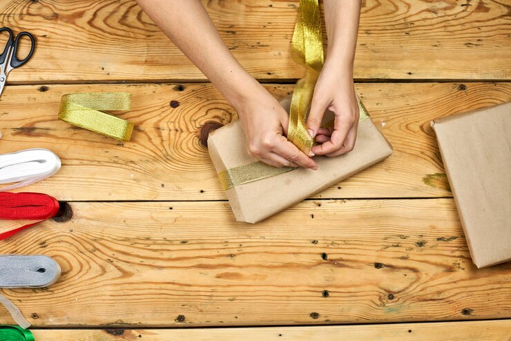 Foto una mujer joven que envuelve el regalo de navidad. haz regalos de navidad. regalos de navidad diy para amigos y familiares.