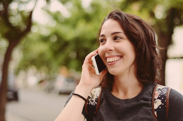 Mujer joven que habla en su teléfono móvil.