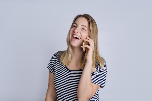 Mujer joven que habla en el teléfono inteligente