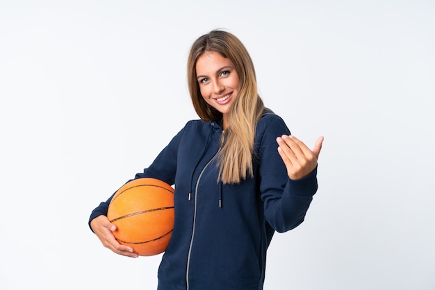 Mujer joven que juega a baloncesto sobre blanco aislado