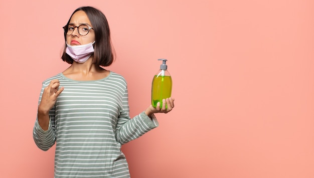 Mujer joven que parece arrogante, exitosa, positiva y orgullosa, apuntando a sí misma