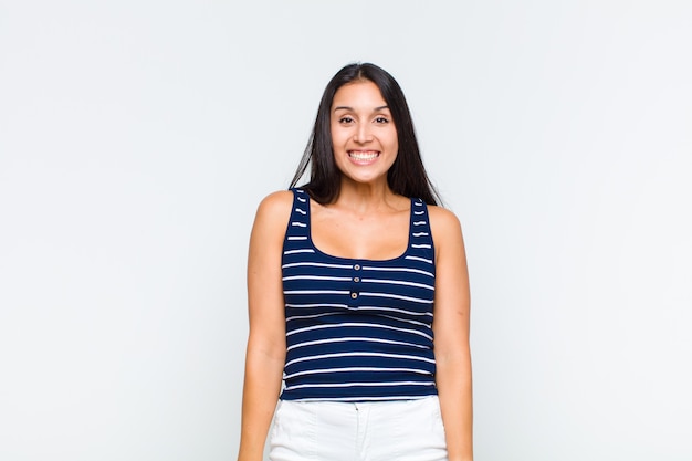 Mujer joven que parece feliz y tonta con una sonrisa amplia, divertida y chiflada y los ojos bien abiertos