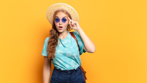 Foto mujer joven que parece sorprendida, con la boca abierta, conmocionada, dándose cuenta de un nuevo pensamiento, idea o concepto