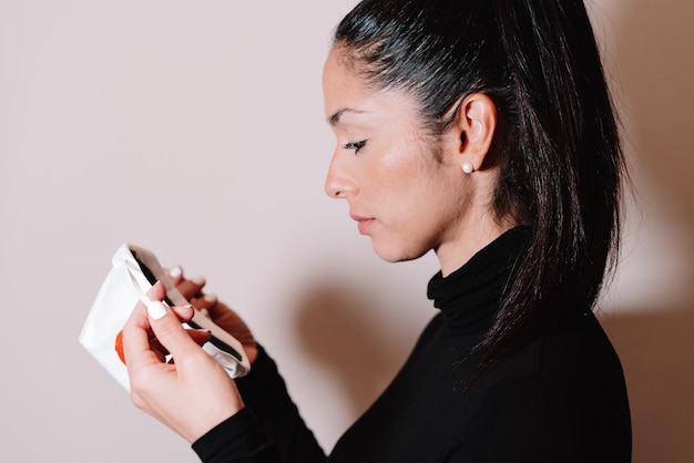 Mujer joven que pone y una mascarilla