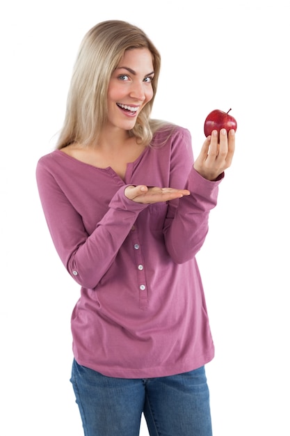 Mujer joven que presenta una manzana