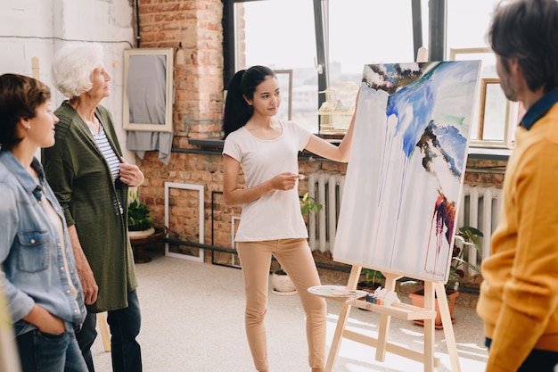 Mujer joven que presenta la pintura