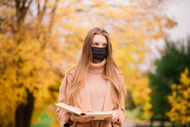 Una mujer joven que se protege del virus corona cuando camina en el parque