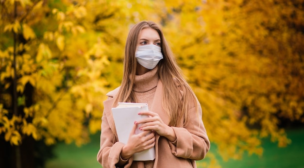 Una mujer joven que se protege del virus corona cuando camina en el parque