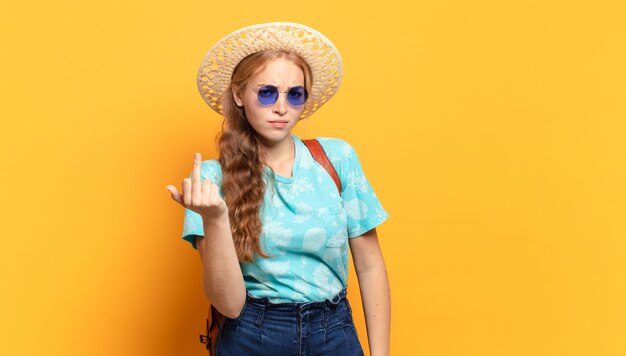 Mujer joven que se siente enojada, molesta, rebelde y agresiva, moviendo el dedo medio, contraatacando