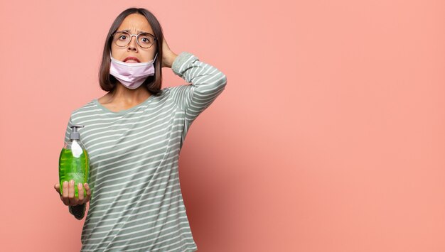 Mujer joven que se siente estresada, preocupada, ansiosa o asustada, con las manos en la cabeza, presa del pánico por el error