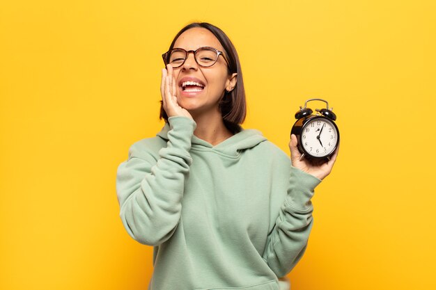 Mujer joven que se siente feliz, emocionada y positiva, dando un gran grito con las manos al lado de la boca