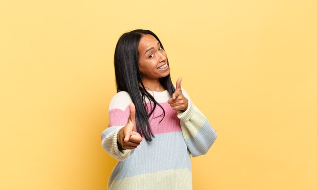 Mujer joven que se siente feliz, fresca, satisfecha, relajada y exitosa, apuntando a la cámara, eligiéndote