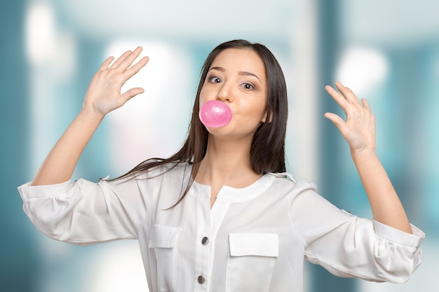 Mujer joven que sopla chicle