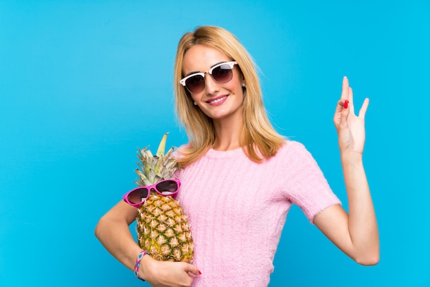 Mujer joven que sostiene una piña con gafas de sol