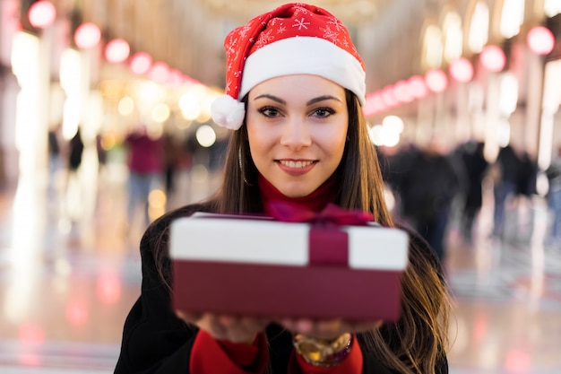 Mujer joven que te da un regalo para Navidad