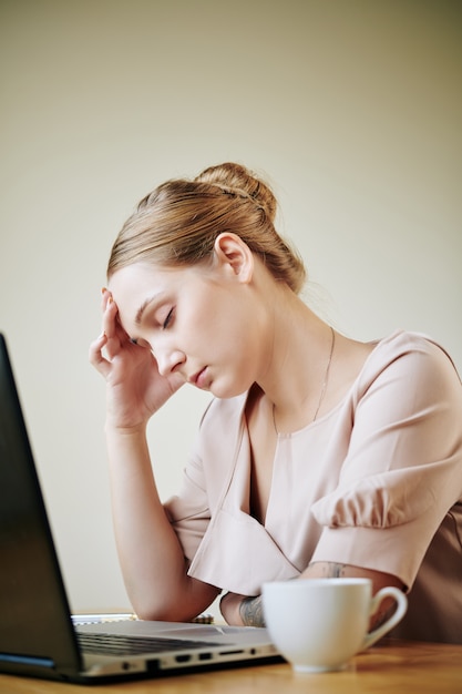 Mujer joven que tiene dolor de cabeza