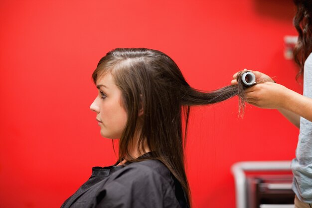 Mujer joven que tiene su pelo rodado