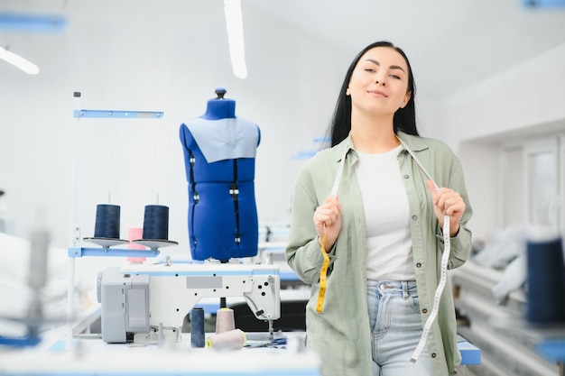 Mujer joven que trabaja como costurera en la fábrica de ropa