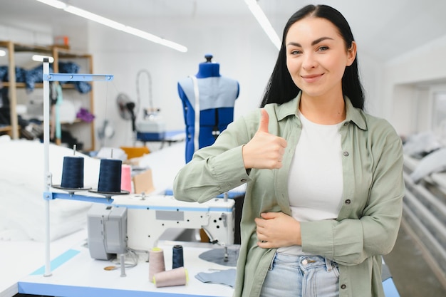 Mujer joven que trabaja como costurera en la fábrica de ropa