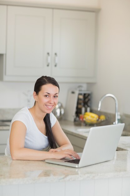 Mujer joven que trabaja en la computadora portátil