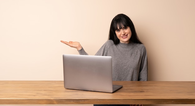 Mujer joven que trabaja con su computadora portátil con copyspace con dudas