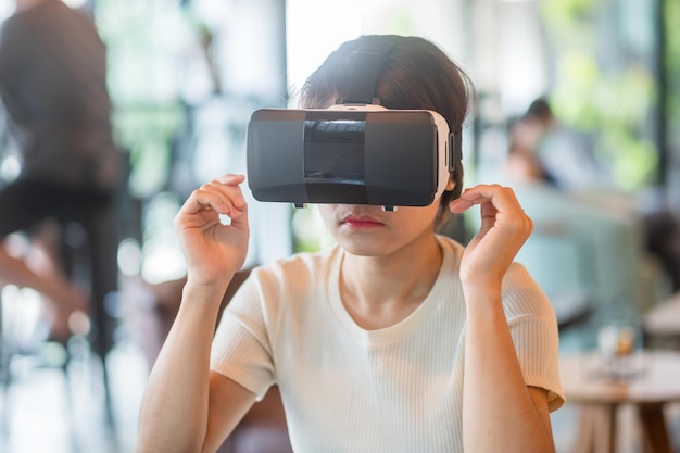 Mujer joven que usa auriculares de realidad virtual VR Futuro tecnología digital entretenimiento de juegos metaverso NFT y concepto de ciberespacio 3D