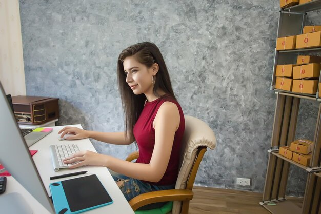 Mujer joven que usa una computadora portátil Éxito de los empresarios al hacer negocios Envío Ventas en línea