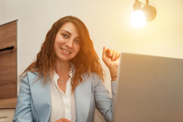 Mujer joven que usa una computadora portátil en la sala de oficina en casa trabajo distante compras en línea o educación