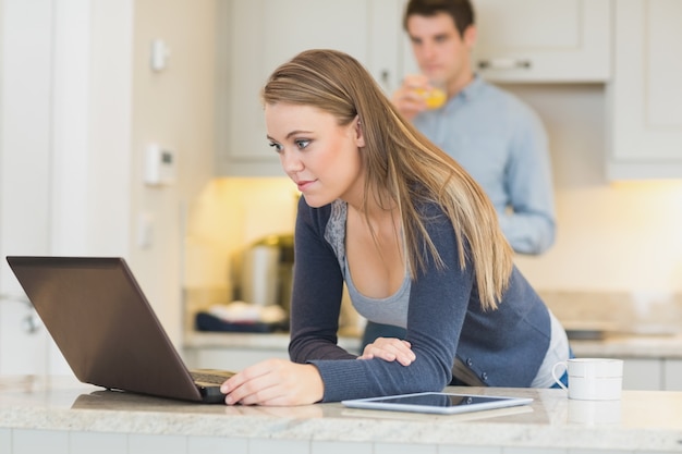 Mujer joven que usa la computadora portátil