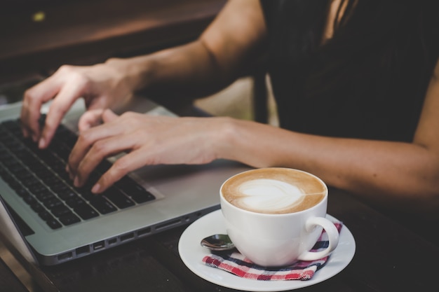 Mujer joven que usa la computadora portátil