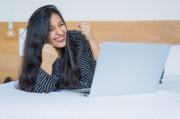 Mujer joven que usa la computadora portátil